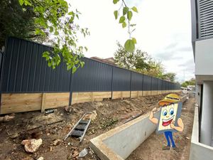 Colorbond fence with treated pine sleeper retaining wall directly under it