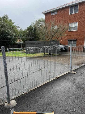 New galvanised roll-top mesh fence across an apartment driveway