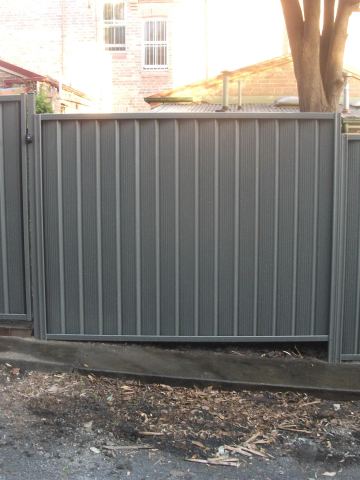 Installed Colorbond sheets forming a privacy boundary with a matching gate opening.