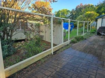 White Colorbond posts and rails set along a paved garden path before the sheets go in