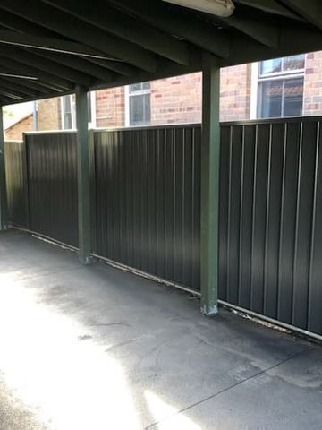 Charcoal Colorbond privacy fence closing the back of an open carport