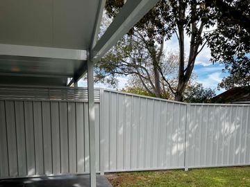 White Colorbond privacy fence seen from under an open patio roof