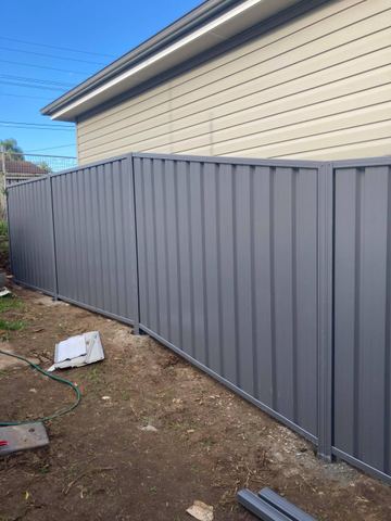 Mid grey Colorbond privacy fence turning a corner on a bare residential block