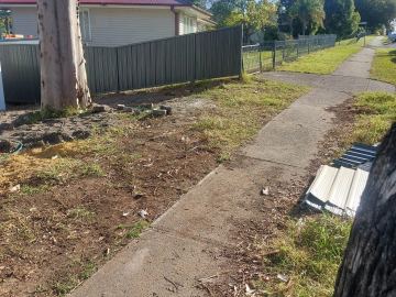 Light grey Colorbond privacy fence along a concrete path with leftover sheeting