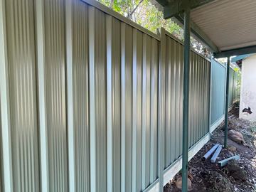 Light grey Colorbond privacy fence running under a patio roof