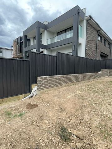 Black Colorbond privacy fence enclosing a new townhouse block