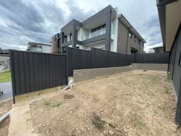 Black Colorbond privacy fence enclosing a new townhouse block