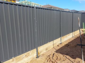 Long charcoal Colorbond privacy fence on a new dirt block