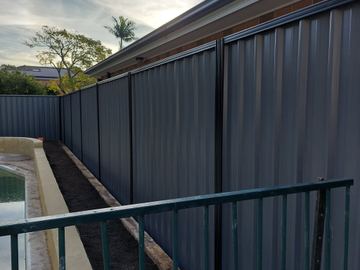 Charcoal Colorbond privacy fence beside a pool handrail