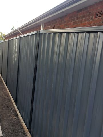 Close view of a charcoal Colorbond privacy fence along a side boundary