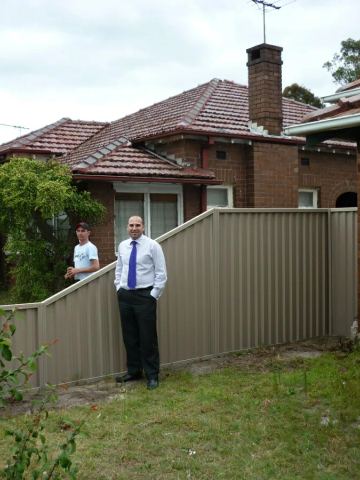 Installed Colorbond sheets running beside lawn and planting.