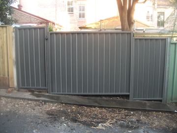 Grey Colorbond pedestrian gate set in a matching fence on the street boundary