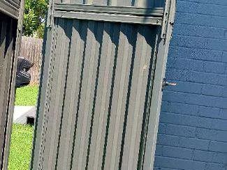 Installed Colorbond sheets forming a privacy boundary with a matching gate opening.