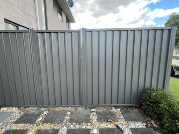 Charcoal Colorbond double gate set in a matching fence on a paved yard