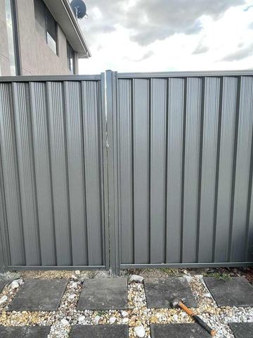 Charcoal Colorbond double gate set in a matching fence on a paved yard
