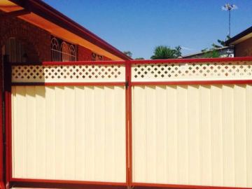 Double driveway gate in cream sheets with diamond lattice and red frame posts.