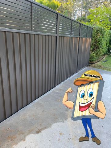 Close view of a mid grey Colorbond privacy fence standing on a concrete pad