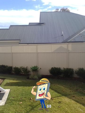 Cream Colorbond privacy fence behind a lawn and a two-storey house balcony