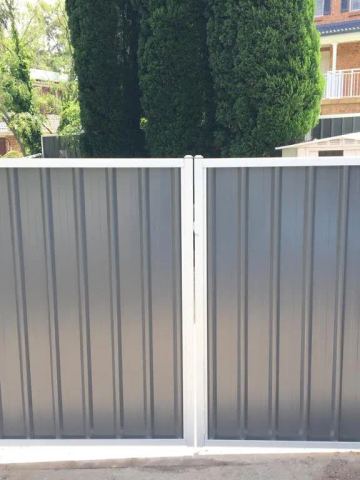 Installed Colorbond sheets forming a privacy boundary with a matching gate opening.
