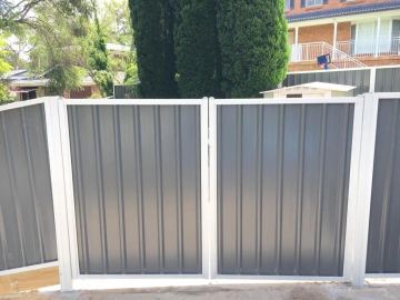 Installed Colorbond sheets forming a privacy boundary with a matching gate opening.