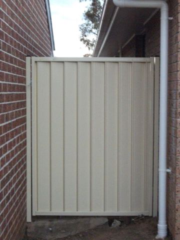 Cream Colorbond pedestrian gate set in a brick wall opening