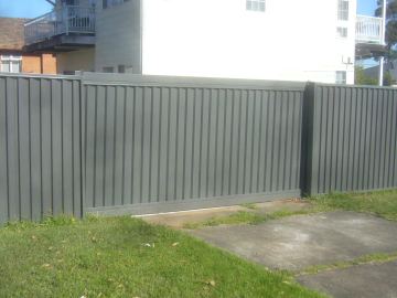 Grey Colorbond sliding driveway gate set in a matching privacy fence