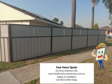 Light grey panels and charcoal posts carry a horizontal slat privacy extension above a concrete footpath and solar-panel roof.