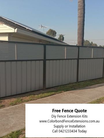 Light grey panels and charcoal posts carry a horizontal slat privacy extension above a concrete footpath and solar-panel roof.