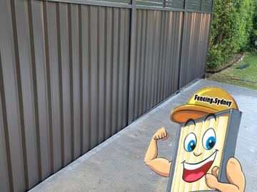 Grey Colorbond privacy fence along a concrete path