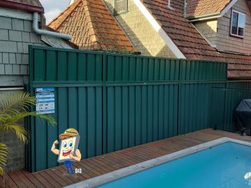 Deep green extended panels with a CPR sign tower beside a timber deck and glass pool fence by shingle siding.