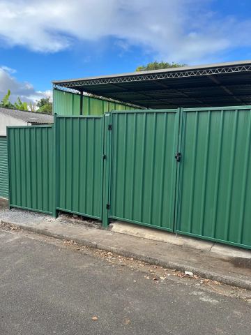 Green Colorbond double gate at a factory driveway