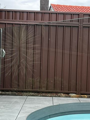 Close view of brown Colorbond sheets and a gate latch