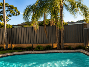 The scene shows a brown corrugated steel fence where sleepers form the base.