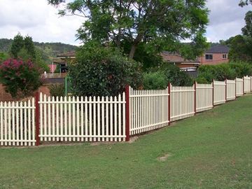 White picket fence running across an open lawn toward neighbouring houses