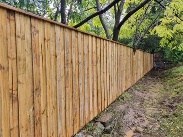 The scene shows a timber paling fence where sleepers form the base.