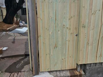 New treated pine palings beside paved areas.