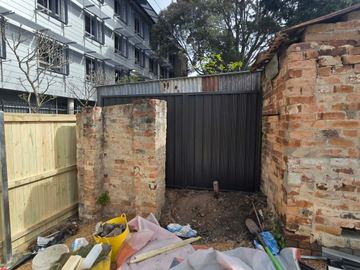 New treated pine palings beside paved areas.