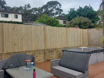 The scene shows a timber paling fence where sleepers form the base.