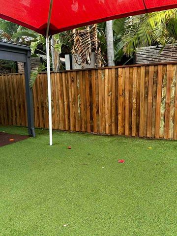 New treated pine palings along a garden boundary.
