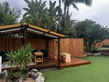 New treated pine palings along a garden boundary.
