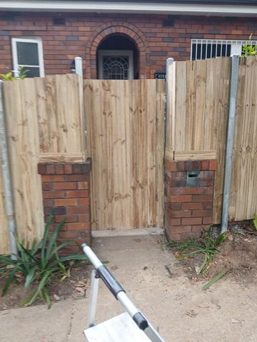 New treated pine palings beside paved areas.