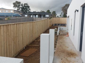 New treated pine palings beside paved areas.
